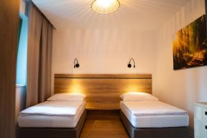 two beds in a room with a headboard at PÚŠŤ rekreačné stredisko in Prievidza