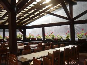 a large room with tables and chairs and flowers at Pensiunea Silvania in Statiunea Borsa