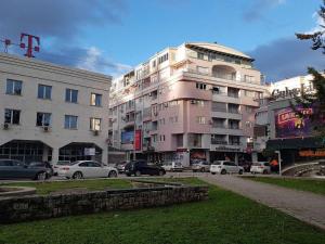 a parking lot with cars parked in front of a building at Utopia Apartments Ohrid in Ohrid