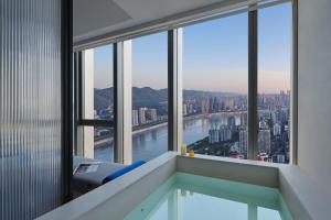 a room with a view of a river and buildings at ISEYA Panoramic Hotel Chongqing Jiefangbei Raffles Plaza in Chongqing