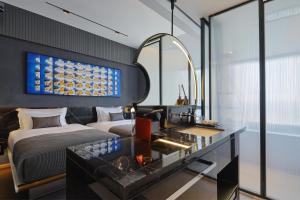 a bedroom with a bed and a desk with a mirror at ISEYA Panoramic Hotel Chongqing Jiefangbei Raffles Plaza in Chongqing