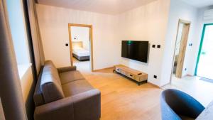 a living room with a couch and a flat screen tv at PÚŠŤ rekreačné stredisko in Prievidza