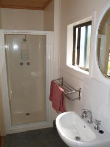 a white bathroom with a shower and a sink at Launceston Holiday Park Legana in Legana
