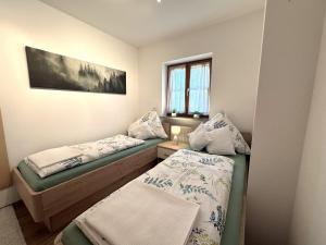 a small room with two beds and a window at Ferienwohnung Heidi mit Oberstaufen PLUS in Oberstaufen