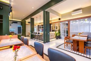 a restaurant with tables and chairs and a bar at Omni Rooms by Sinergi in Semarang