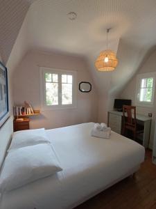 ein Schlafzimmer mit einem großen weißen Bett und einem Schreibtisch in der Unterkunft Ti Maen in Frehel