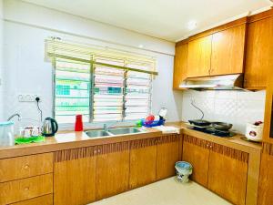 a kitchen with wooden cabinets and a sink and a window at HmHome-Three in Sibu