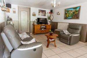 a living room with two couches and a tv at Chambres et table d'hôtes Floromel La Souterraine en rez de chaussee in La Souterraine