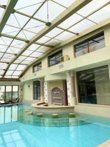 an indoor swimming pool with a glass ceiling at Long Sunny Holiday in Shkorpilovtsi