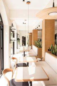 a restaurant with tables and chairs and potted plants at Akti Hotel Kavala in Paleo Tsifliki