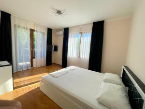 a bedroom with a large white bed and windows at Long Sunny Holiday in Shkorpilovtsi +43 photos