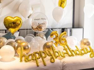 a bed with gold balloons and a happy birthday sign at ORIENTAL HOTEL UNIVERSAL CITY in Osaka