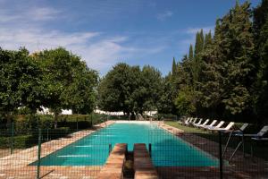 a swimming pool with lounge chairs and trees at Monasterio de San Francisco in Palma del Río