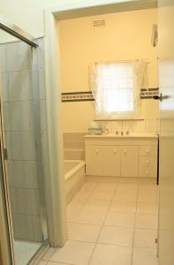 本迪戈的住宿－克瑙斯度假屋，带淋浴、盥洗盆和浴缸的浴室