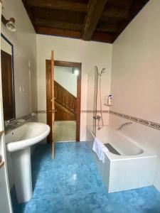 a bathroom with a tub and a sink at La Casona de Ardines in Arenas de Cabrales