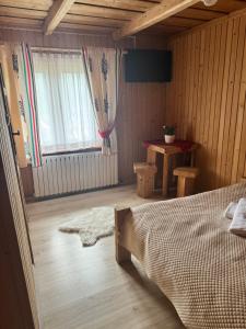 a bedroom with a bed and a window at U Młynorza Jacuzzi ogrodowe całoroczne in Suche