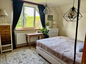 a bedroom with a bed and a window and a table at Private Villa with sauna, hot tub, playground and outside lounge area in Pärnu +48 photos