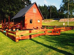 a wooden fence in front of a barn at Kaszubskie Domki Nad Jeziorem Bluj in Głodowo +3 photos
