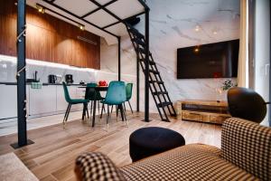 ein Wohnzimmer mit einer Treppe und einem Tisch und Stühlen in der Unterkunft Laguna Beskidów Resort - Apartament B35 in Zarzecze
