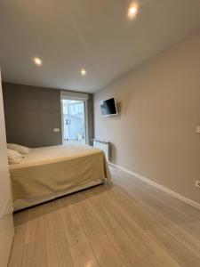ein Schlafzimmer mit einem Bett und einem Fernseher an der Wand in der Unterkunft Nuevo Apartamento en el centro by Lujo in Pamplona