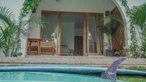 a swimming pool with a shark in front of a house at Rumah Markisa Batukaras in Batukaras