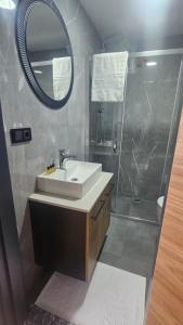 a bathroom with a sink and a shower with a mirror at Mimoza Konyaaltı in Antalya