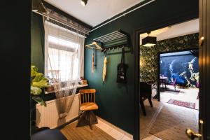 a room with a green wall and a wooden chair at Villa Papírkutya in Veszprém