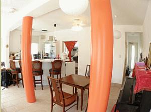 a dining room and kitchen with an orange pillar at Cha Villa in Zamami