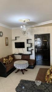 a living room with a couch and a table and a television at Appartement Paisible et Impeccable pour Toute la Famille in Martil