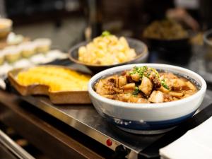 a bowl of food on a counter with other foods at APA Hotel Yodoyabashi Kitahama Ekimae in Osaka