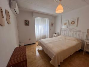 a white bedroom with a bed and a window at Impecable piso a 300 mt del mar! in Puerto de Mazarrón