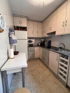 a kitchen with white cabinets and a white refrigerator at Impecable piso a 300 mt del mar! in Puerto de Mazarrón