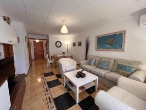 a living room with a couch and a table at Impecable piso a 300 mt del mar! in Puerto de Mazarrón