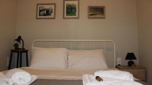 - une chambre avec un lit, des serviettes et des photos sur le mur dans l'établissement A&B My Sweet Home 2, à Anatolí