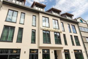 een groot wit gebouw met een bord erop bij Central Hotel & Lounge Adult Only in Goslar