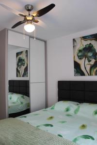 a bedroom with a bed and a ceiling fan at Apartman Nivalis in Čapljina