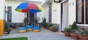 a patio with a colorful umbrella and some plants at Fam HomeStay in Jorhāt