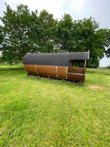 a wooden boat with a black roof in a field at Le tonneau de Louise in Bretteville-du-Grand Caux