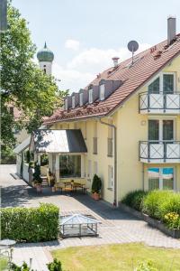 ein Haus mit einer Terrasse und einem Wasserturm im Hintergrund in der Unterkunft Hotel Beim Schrey in Kirchheim