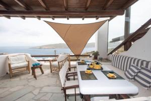 um pátio com uma mesa e cadeiras e o oceano em Apt with Amazing Balcony View of Mykonos em Agios Sostis Mykonos