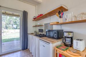 a kitchen with a counter top with a microwave at Mas des Cypres - Mazet 4 in Saintes-Maries-de-la-Mer +15 photos