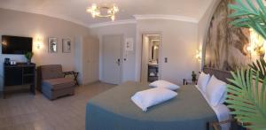 a living room with a bed and a couch and a chair at Triena Rooms in Mythimna