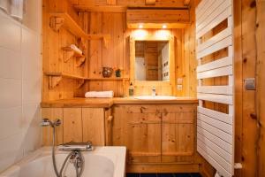 baño de madera con bañera y lavamanos en Chalet des Cristaux Happy Rentals, en Chamonix-Mont-Blanc