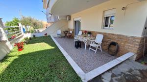 a patio with a table and chairs in a backyard at LY apartment in Kallithea Halkidikis