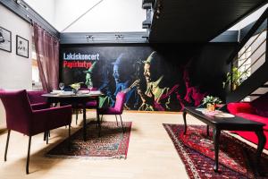 a restaurant with tables and chairs and a large painting on the wall at Villa Papírkutya in Veszprém