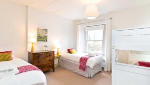 a bedroom with two beds and a window at Edge Cottage in Curbar
