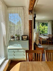 a dining room with a blue dresser and a window at Private Villa with sauna, hot tub, playground and outside lounge area in Pärnu