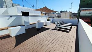 a deck with two benches and a table and chairs at Terraza Suites Benidorm in Benidorm