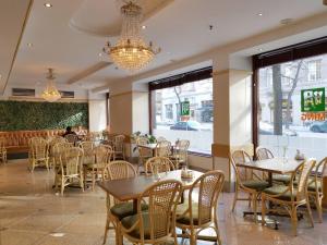 a dining room with tables and chairs and a chandelier at Crystal Plaza Hotel in Stockholm