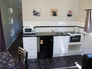 a small kitchen with a sink and a microwave at Launceston Holiday Park Legana in Legana